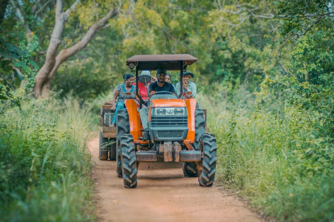 Image of a family riding a tractor in a rural area